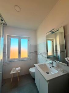 a bathroom with a sink and a toilet and a mirror at Maria House in Parghelia