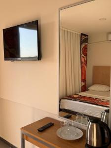 a mirror in a room with a bed and a television at Cnr in Manavgat