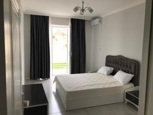 a bedroom with a bed and a large window at Astara Villa Boutique Hotel in Astara