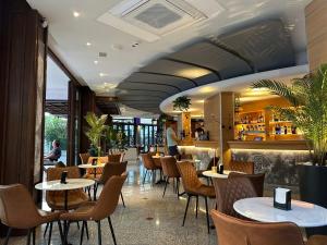 ein Restaurant mit Tischen und Stühlen und einer Bar in der Unterkunft Hotel DOLCEVITA Park & Beach included in Lido di Jesolo