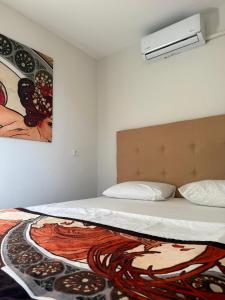a bedroom with a bed with a painting on the wall at Cnr in Manavgat