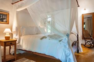 a bedroom with a bed with a canopy at POUSADA CARMELITHA in Trancoso