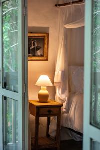 a lamp on a table next to a bed at POUSADA CARMELITHA in Trancoso