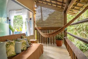 a room with a couch and a hammock at POUSADA CARMELITHA in Trancoso