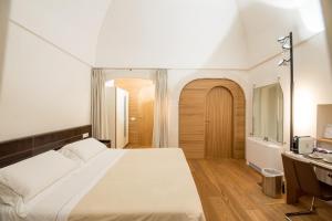 ein Schlafzimmer mit einem großen Bett und einem Schreibtisch in der Unterkunft Dimora Intini in Noci