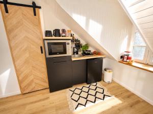 a kitchen with a stove and a microwave at MRODBNB - Appart Neuf - Vue Mer - 25m Plage & Resto - Ciné - cheminée - Popcorn in Cancale +11 photos