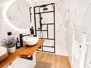 a bathroom with a sink and a mirror at MRODBNB - Appart Neuf - Vue Mer - 25m Plage & Resto - Ciné - cheminée - Popcorn in Cancale
