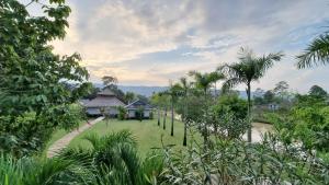 a garden with a house in the middle of it at Khla Lodge in Kampot