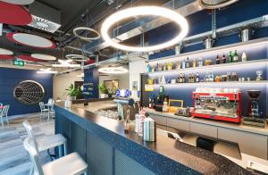 a bar in a restaurant with blue walls at MEININGER Hotel Genève Centre Charmilles in Geneva