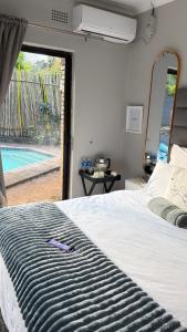 a bedroom with a bed and a view of a pool at The Chalant in Tzaneen +26 photos