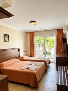 ein Hotelzimmer mit drei Betten und einem Fenster in der Unterkunft Hotel Keskin in Dalyan + 31 Fotos