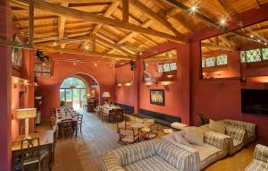 a large room with red walls with couches and tables at La Pimpinella di Semifonte in San Donnino