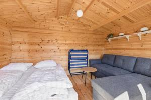 a room with a bed and a couch in a cabin at Close To The Beach With Outdoor Spa in Slagelse