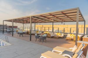 a patio with chairs and tables on a roof at The Grand Lux Hotel in Doha