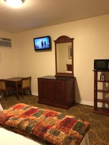 um quarto com uma cama, uma cómoda e um espelho em Waterbury Big Apple Motel em Waterbury