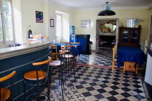 a bar with stools in a room with a piano at Château Lagelouse in Mimbaste