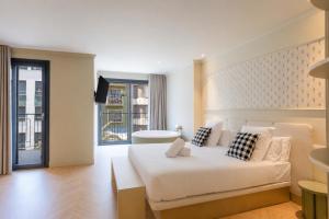 a bedroom with a large white bed and a window at AT Boutique Alma in Alicante