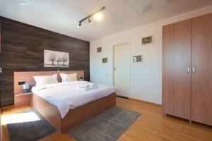 a bedroom with a large bed and a wooden wall at Old Town Smârdan Apartment - Central Lively Area in Bucharest