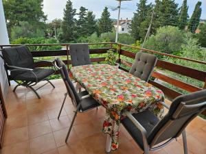 a table and four chairs on a balcony with a table at Apartments Vidakovic in Ugljan