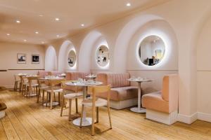 a restaurant with tables and chairs and a mirror at Hôtel Oratio in Paris