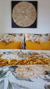 a bed with yellow pillows and a blanket at greenlodge pornplatthof in Auna di Sopra +20 photos