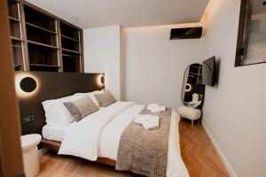 a bedroom with a large white bed and a chair at Maison Sidra in Thessaloniki