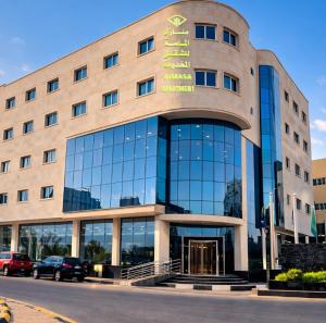 a building with a sign on the front of it at منــازل الماسة للشقق المخدومة in Unayzah