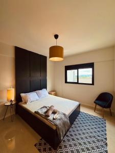 a bedroom with a large bed with a black headboard at Apartamento Sofisticado com terraço centro Pouso Alegre in Pouso Alegre +58 photos