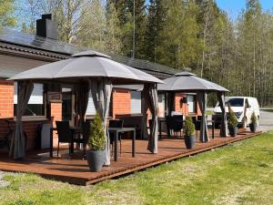 a deck with chairs and umbrellas on a house at Kangaskartano in Keitelepohja