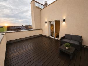 a balcony with a couch and a table on a building at Apart Home Tel AHT in Krapkowice