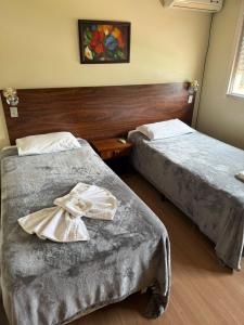 a hotel room with two beds and a picture on the wall at Cyro Palace Hotel Ltda in Caçapava do Sul