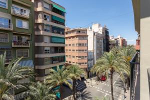 a city street with palm trees in front of buildings at AT Boutique Alma in Alicante