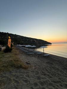 a group of umbrellas and chairs on a beach at Kamares Bay Escape in Gythio