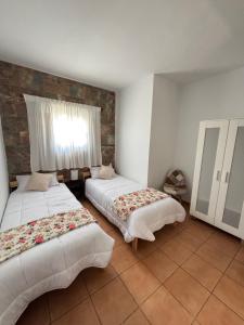 a bedroom with two beds and a window at Casa Victoria in Antigua