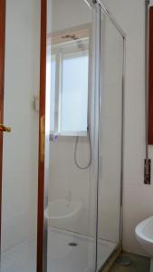 a glass shower in a bathroom with a sink at City Centre Cozy Apartment in Porto +24 photos