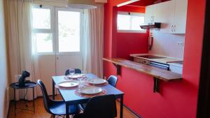 a kitchen with a table with chairs and a red wall at City Centre Cozy Apartment in Porto