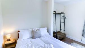 a bedroom with a bed with white sheets and pillows at Spacious and Modern Durham home in Gilesgate