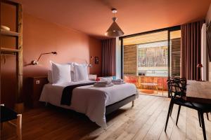 a bedroom with a bed and a table and a window at Le Moulin de Nouara in Ambert