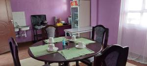 a table and chairs in a kitchen with purple walls at Crown Accommodation Narok in Narok