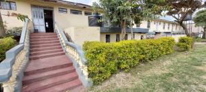 a house with a staircase leading to the front door at Crown Accommodation Narok in Narok