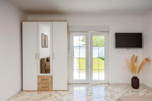 a white living room with a sliding glass door at Villa Kaplan Verde in Stolac