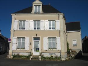 a white house with white windows and a black roof at La Maison d'Héloïse in Pruillé