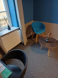 a room with a chair and a table and a chair at Double room 5 in the center of Saeby in Sæby