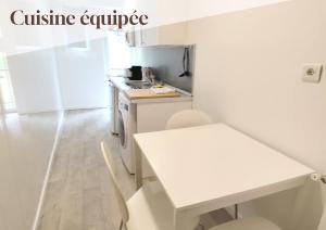 a kitchen with a white counter and a white table at Studio 6, Eaux-Chaudes, proche Laruns & Espagne in Laruns