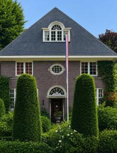 a house with a flag in the front yard at Deventer Heritage en Boutique B&B, museumhuis "De Worp", het huis met de theekoepel, logeren in authentiek historisch erfgoed in Deventer