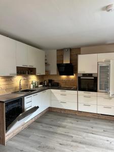 a kitchen with white cabinets and a sink at Boardwalk center in Mayrhofen