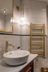 a bathroom with a white sink and a mirror at The Windmill On The Common in London