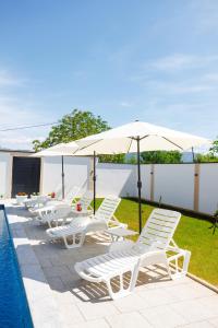 a row of chairs and umbrellas next to a pool at Villa Kaplan Verde in Stolac