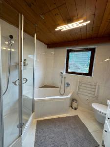 a bathroom with a shower and a tub and a toilet at Boardwalk center in Mayrhofen +5 photos