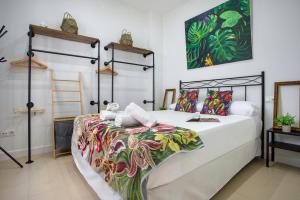 a bedroom with a large bed with a colorful blanket at Sunstay Arroyo House Velez in Vélez-Málaga